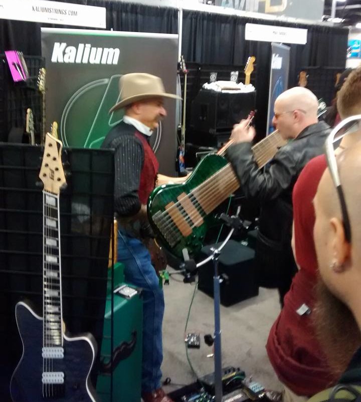 A large 8-string bass being showcased at the NAMM show.